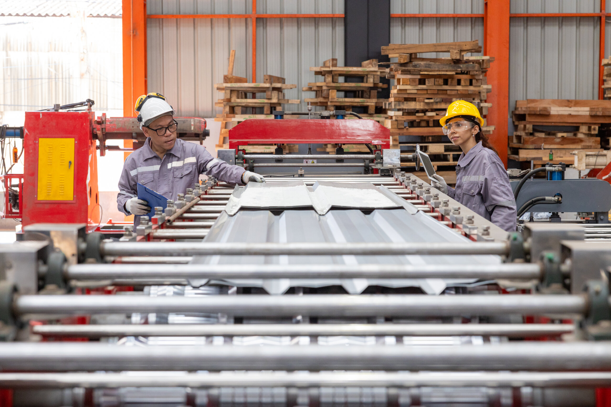 Engineers Overseeing Metal Sheet Production in Factory